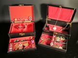 two boxes that have some jewelry in them on a table