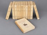 several books are stacked on top of each other on a gray surface