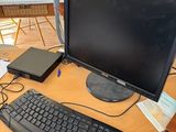 a desk with a computer, keyboard, mouse, and other items on it