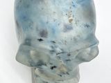 a blue glass skull head on a white surface