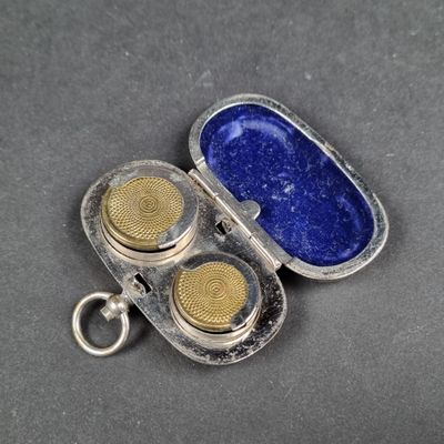 un étui en argent avec deux boutons en or à l'intérieur