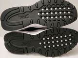 the soles of a pair of black shoes on a white surface