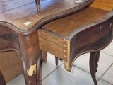 a table with a drawer underneath it on a tile floor