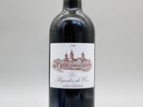 une bouteille de vin rouge posée sur une table blanche