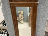 un miroir posé par terre à côté d'un ours en peluche