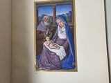 an open book with a painting of a woman holding a baby
