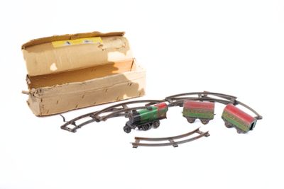 un petit train miniature posé sur les rails à côté d'une boîte en carton
