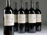 six bottles of wine are lined up in a row on a table