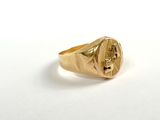 a close up of a gold signet ring on a white surface