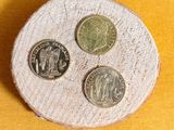 three coins sitting on top of a piece of wood