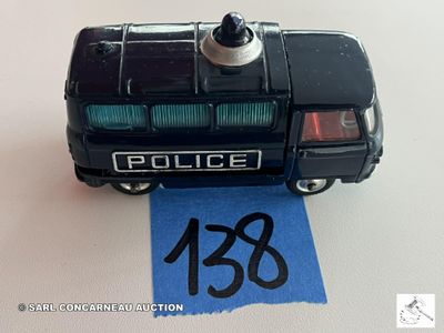 une petite voiture de police miniature posée sur un morceau de papier bleu
