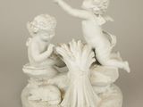 a white statue of two cherensils sitting on top of a table