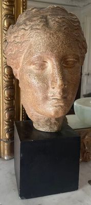 a statue of a woman ' s head sitting on a table