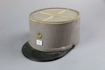 grey hat with gold trim on top of it sitting on a gray surface