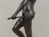 statue of a woman holding a bow and arrow on a wooden table