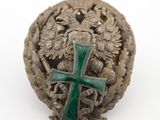 une vieille croix argentée et verte posée sur une boule