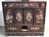 a wooden cabinet with many drawers and a vase on top of it