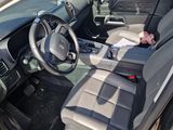 a man sitting in the driver ' s seat of a car