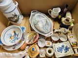 une boîte remplie d'objets divers, posée par terre