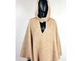 a woman wearing a beige cape with a hood on her head