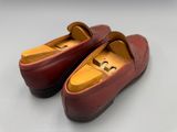 une paire de chaussures en cuir rouge posées sur une surface blanche