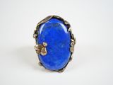 a close up of a blue stone ring on a white surface