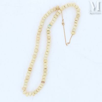 a close up of a necklace on a white surface