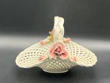 un gros plan d'un panier blanc orné de fleurs roses