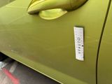 a sticker on the door handle of a green car