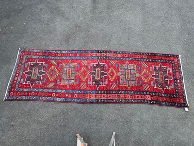 une photo d'un tapis rouge posé par terre à côté d'une paire de chaussures