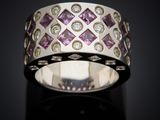 a close up of a ring with diamonds on a black surface