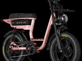 un gros plan d'un vélo électrique rose sur fond noir
