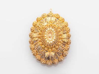 an image of a gold broochle on a white background