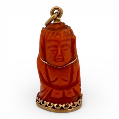 Pendentif en corail sculpté formant un Bouddha.