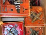 des boîtes contenant des jouets variés, rangées dans un carton posé sur une table