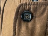 the back of a jacket with a button in the middle of it
