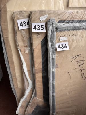 Plusieurs cartons sont empilés les uns sur les autres dans un entrepôt