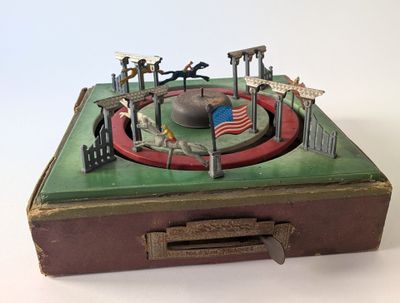an old suitcase with a toy carousel in it