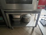 a stainless steel shelf with pots and pans on it