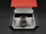 une image représentant une montre dans un coffret posé sur une surface noire