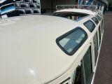 un bus blanc garé sur un parking à côté d'un immeuble