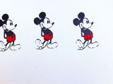 Trois Mickey Mouse vêtus de t-shirts rouges et noirs se tiennent côte à côte.