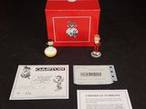 une boîte rouge posée sur une table, contenant une petite figurine