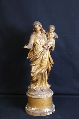 statue of a woman holding a child on a pedestal against a black background