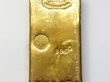 a gold bar sitting on top of a white surface