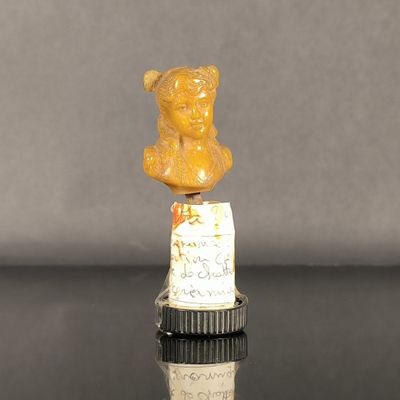 une petite statuette représentant un ours en peluche posée sur une bouteille