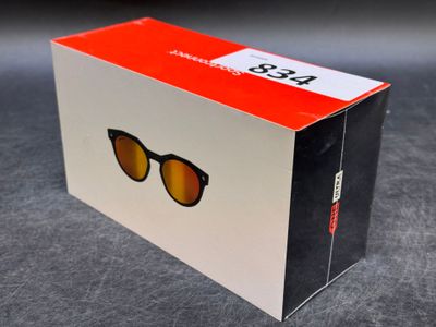 un gros plan d'une boîte sur laquelle est posée une paire de lunettes de soleil