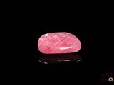 un quartz rose posé sur une surface noire