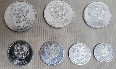 Six types différents de pièces d'argent sont disposés sur une table.