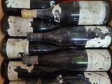 several bottles of wine are in a cardboard box on a table